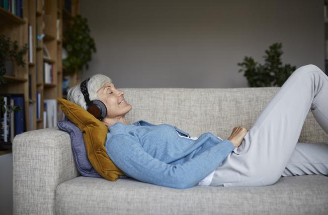 Older woman listening to music on couch