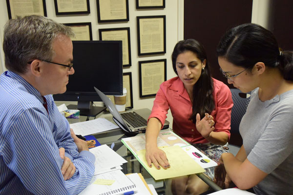 IHPI members discussing ideas around a desk