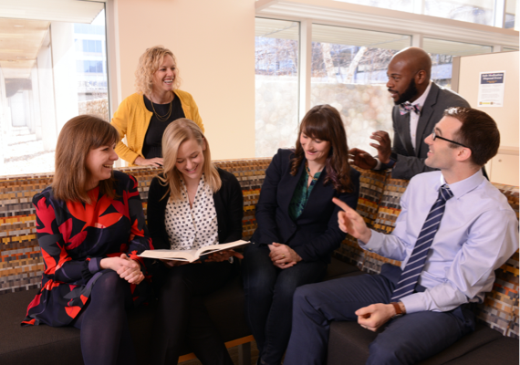 photo of a group of people sitting together around a couch