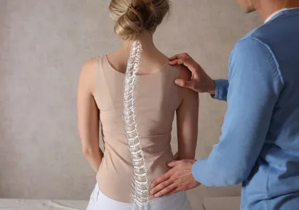 Illustration of a scoliosis spine over a woman's back with a provider's hands