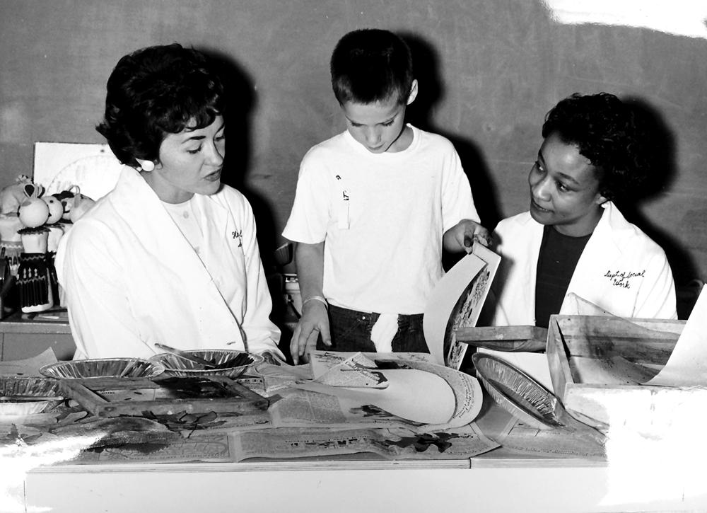Two researchers work with a child at the U-M School of Social Work, 1950s