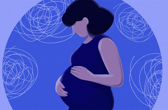 Pregnant woman cradling belly in front of blue spirals