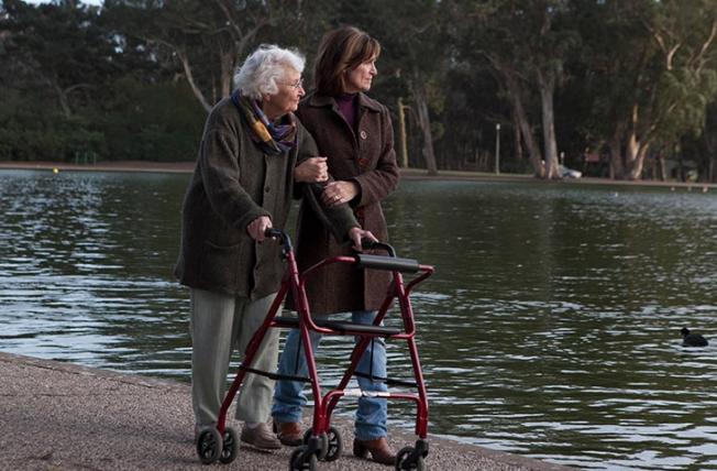 Older woman and daughter walking by pond